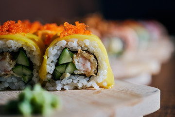 Various kinds of sushi served on wooden table