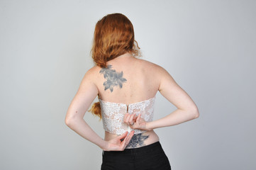 frau in corsage öffnet bluse