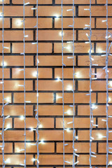 Christmas electric garland on red brick wall background