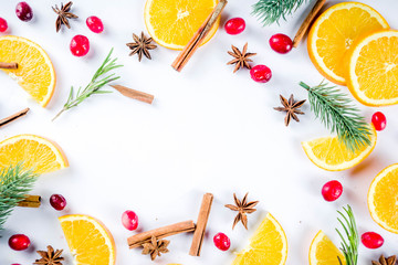 Winter autumn drink and food ingredients. Cranberries, sliced oranges, cinnamon, rosemary, anise for cooking cocktails, with christmas tree branches. Flatlay on white background. Top view copy space