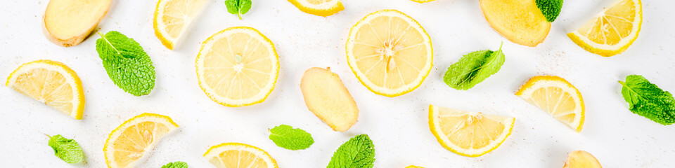 Mojito, lemonade cocktail or sour infused water ingredient. Flatlay with sliced lemon, ginger and...
