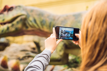 woman use mobile phone and blurred image of people in the dinosaur exhibition