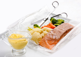 Salmon cooked sous vide with vegetables on a white background