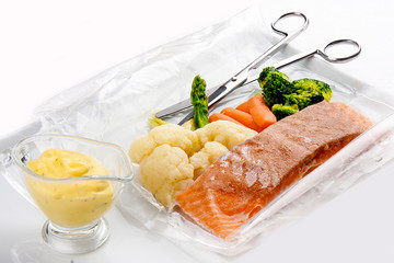 Salmon cooked sous vide with vegetables on a white background