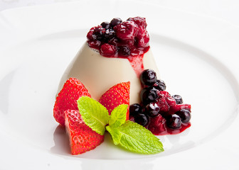 Dessert panna cotta with fresh berries on white background
