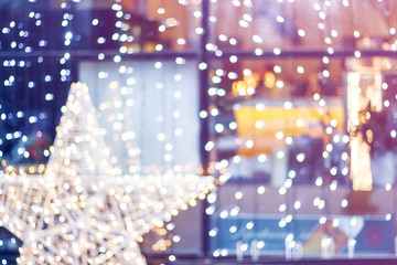 Fototapeta na wymiar Blurred New Year decoration background. Star lighting in a cafe