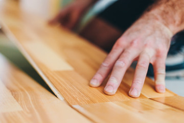 The master skillfully installs parquet - floating floor - floor work during finishing