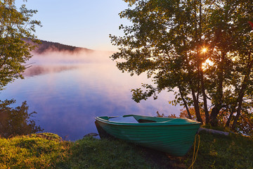 Fototapeta na wymiar Peaceful morning landscape with fog and boats