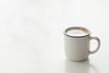 Close up a vintage cup of hot latte coffee on white vintage desk, coffee with milk