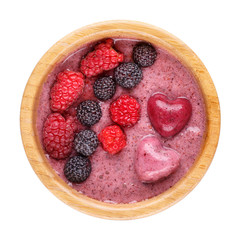 Smoothie bowl isolated on white background. Delicious pink berry smoothie topped with raspberry and blackberry. Healthy breakfast. Top view.