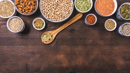 Composition of different types of legumes in bowls on wooden background