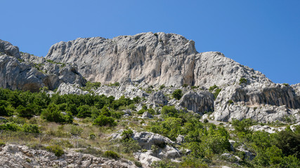 Fototapeta na wymiar Mountain landscape with rugged white limestone cliffs on a sunny summer day, Biokovo mountain range in Croatia. 