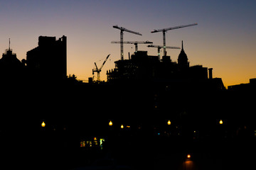 Old Montreal silhouette and cranes at dusk