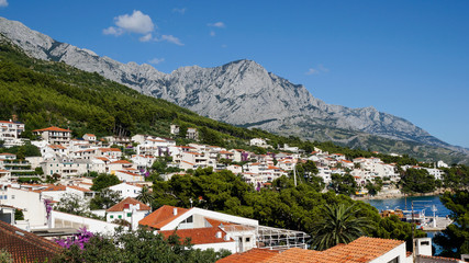 Fototapeta premium Cityscape of the beautiful Croatian town, Brela situated on the Dalmatian Coast at the base of the Biokovo mountain. Charming village at the Adriatic Sea.