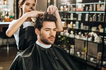  Beautiful young hairdresser cutting hair to handsome man in beauty salon © LIGHTFIELD STUDIOS