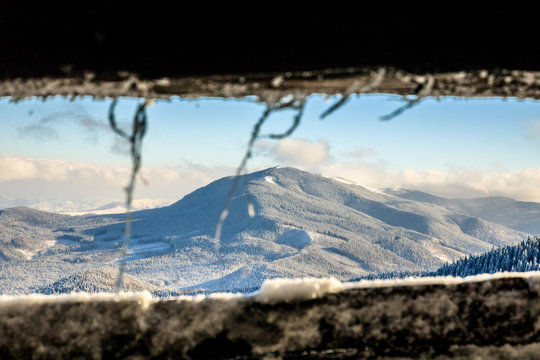 Fototapeta view from window on snowy winter mountains