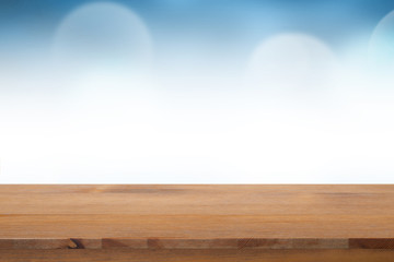 Empty of top wooden desk with blurred light blue gradient bokeh abstract background