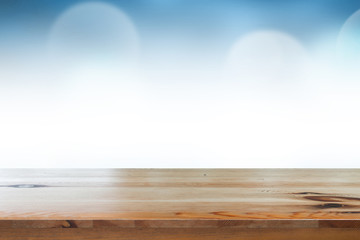 Empty of top wooden desk with blurred light blue gradient bokeh abstract background