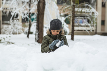 Fototapeta na wymiar little boy playing in snow outdoor