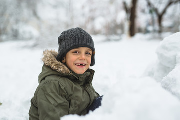 Fototapeta na wymiar portrait of happy boy playing outdoor in snow