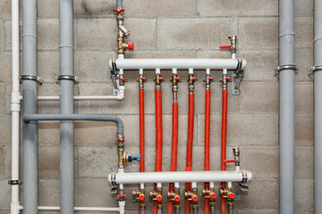 Pipes of heating and water supply system on the background of a concrete wall.