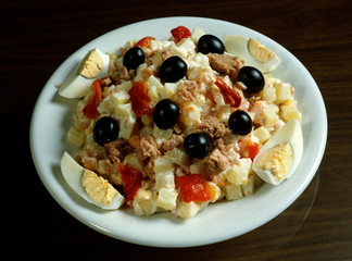 Plato con ensaladilla rusa con patata, huevo cocido, pimiento, salsa maionesa, atún y aceitunas.