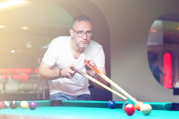 Male plays a billiard at the club. Caucasian mcaucasianan playing spending time on recreation. Play and fun concept. Toning