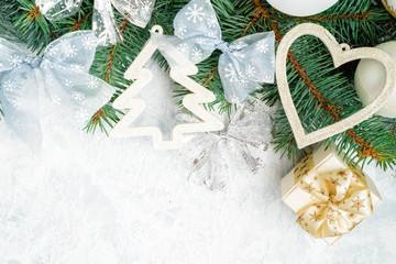 Christmas composition. Christmas gift, knitted blanket, pine cones, fir branches on wooden white background. Flat lay, top view, copy space