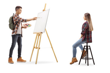 Naklejka premium Male teen student painting a girl model on a canvas