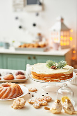 Christmas cake and sweets on table. Christmas  decorations with lights background. Happy New Year! Christmas greeting card. Winter card template. Xmas concept. Holiday Banner. Feast of Nativity. 