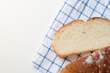 Fresh home made bread on white table background with napkin