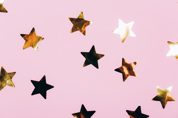 Many beautiful golden stars on pink background. Flat lay style.