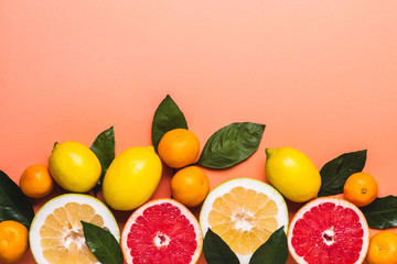 Living coral background with fresh citrus fruits. Healthy food concept
