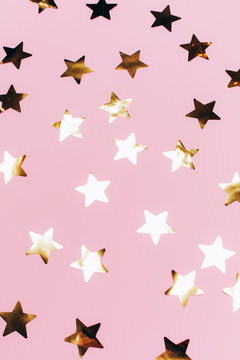 Many beautiful golden stars on pink background. Flat lay style.