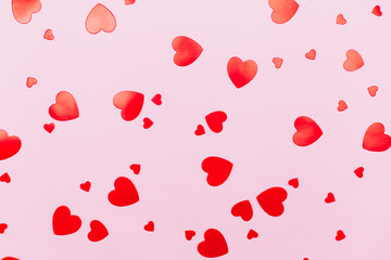 Beautiful heart shaped confetti on pastel pink background. Can be used as backdrop for your design with love concept.