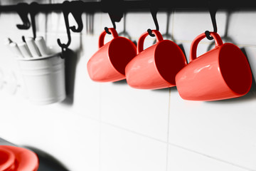 Interiors of modern kitchen shelf with trendy coral color cups and plates.