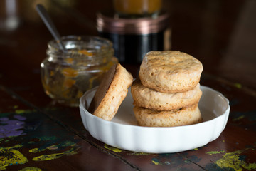 Close up of homemade scones in white bowl on vintage wooden table