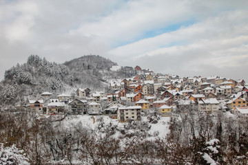Fototapeta na wymiar Uzice town in Serbia covered with snow. Cloudy winter day