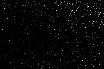 natural snow on black night background with selective focus