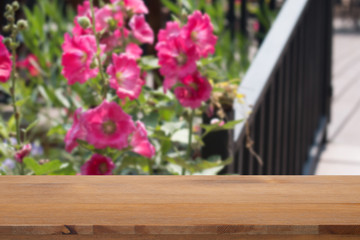 Empty desk with Hollyhocks blooming in  garden
