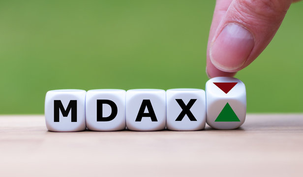 Hand is turning a dice and changes the direction of an arrow symbolizing that the German Stock Index MDAX is changing the trend and goes up instead of down (or vice versa)