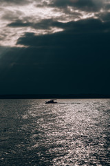 sunset over sea with a boat ion the horizon