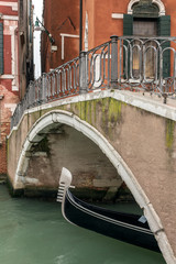 Traditional venetian gondola on the side canal in Venice, Italy