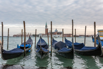San Giorgio Maggiore church and gondolas at cloudy day in Venice, Italy.