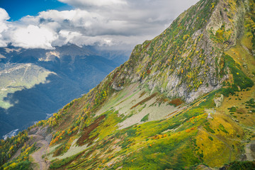 the mountainside is covered with colorful flora. Mountains painted with the colors of autumn. mountain road and mountains in the background