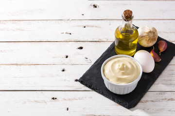 Aioli sauce and ingredients on white wooden table. Copyspace