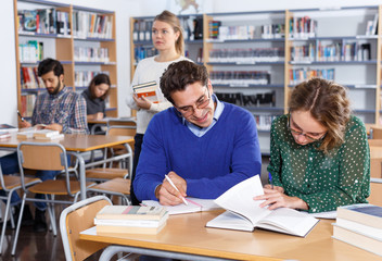 Young people preparing for exam in library