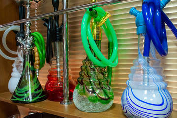 Bright beautiful hookahs on the shop window. Hookah pipes, mouthpieces,  flasks. variety. choose