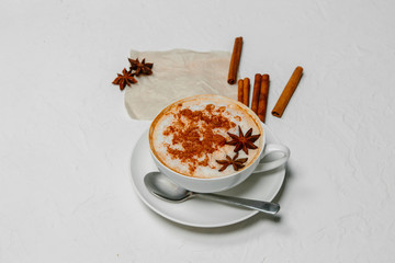 Coffee cappuccino with cinnamon and anise stars on white background