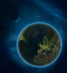 Ireland at night from space with Moon and Milky Way. Detailed planet Earth with city lights and visible country borders.